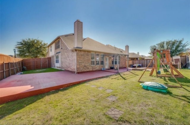 back of property with a yard, a patio, and a playground