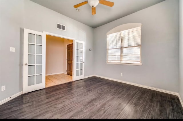 empty room featuring ceiling fan, french doors, and hardwood / wood-style floors