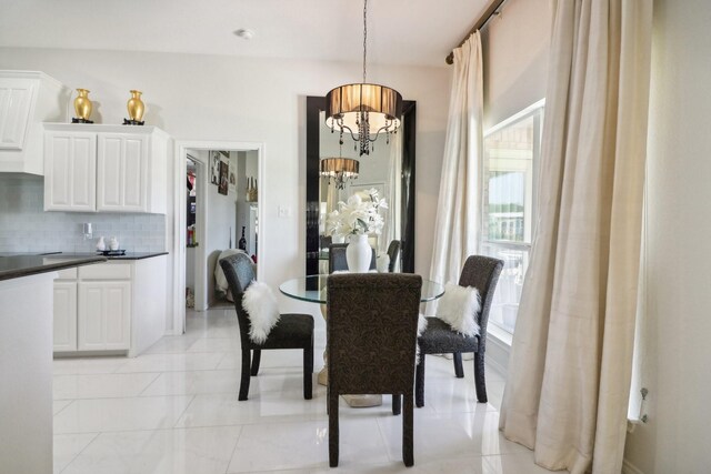 dining space featuring light tile patterned flooring and a notable chandelier