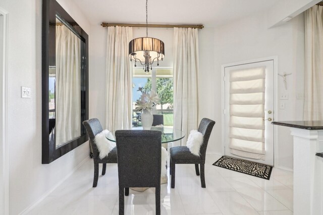 dining area with a chandelier and light tile patterned floors