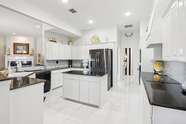 kitchen featuring visible vents, white cabinets, backsplash, a center island, and black appliances