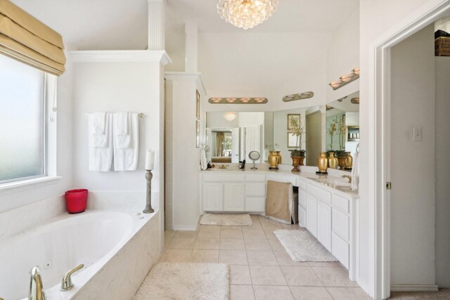 bathroom with tile patterned floors, vanity, and a tub to relax in