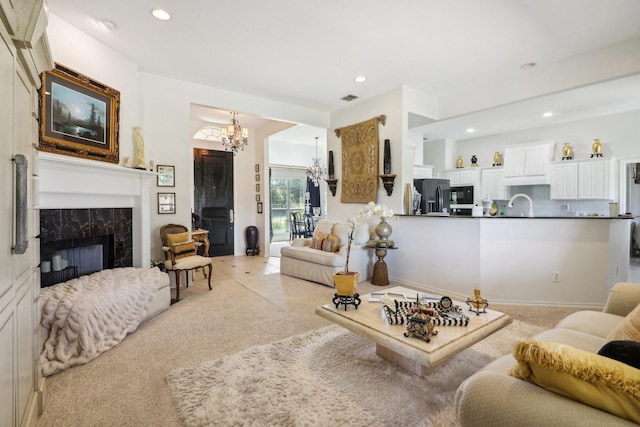 living area featuring a fireplace, recessed lighting, light colored carpet, visible vents, and a chandelier