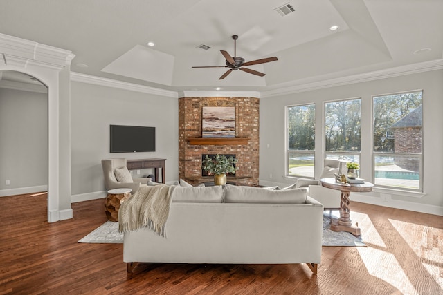 living room featuring ceiling fan, a fireplace, ornamental molding, and hardwood / wood-style flooring