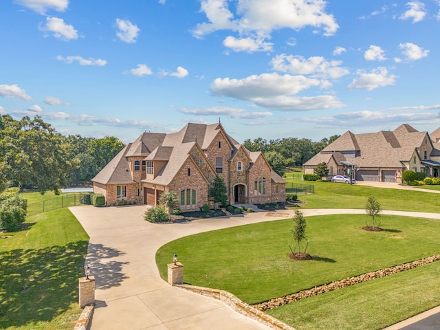 tudor house featuring a front yard and a garage