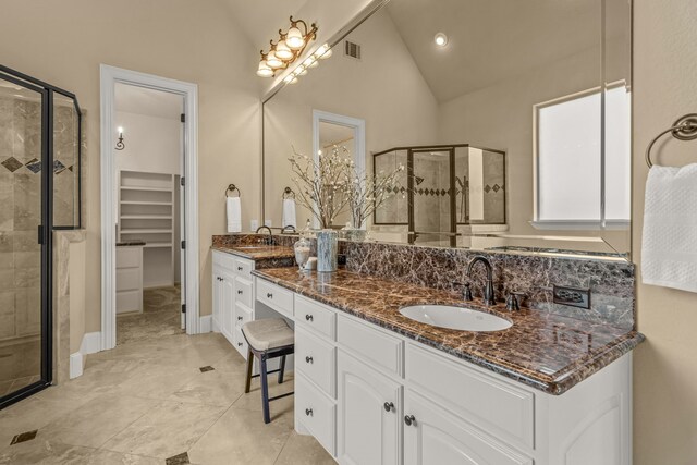 bathroom featuring vanity, walk in shower, and high vaulted ceiling