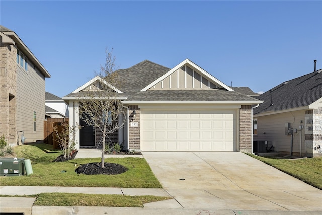 view of front of home featuring a garage, a front lawn, and central air condition unit