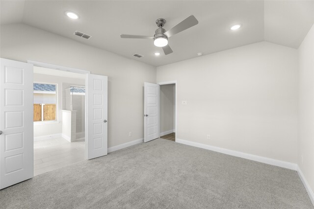 unfurnished bedroom with ceiling fan, lofted ceiling, and light colored carpet