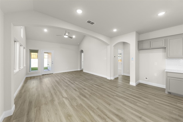 unfurnished living room with light hardwood / wood-style flooring, ceiling fan, and vaulted ceiling