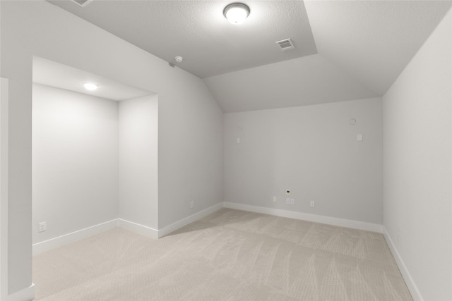 bonus room with vaulted ceiling, light carpet, baseboards, and visible vents