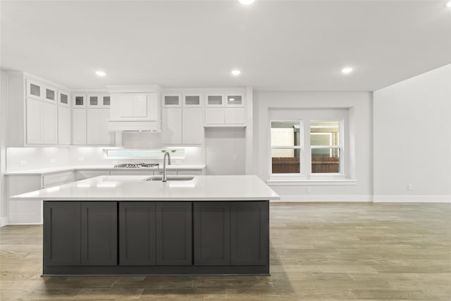 kitchen with a sink, white cabinetry, and baseboards