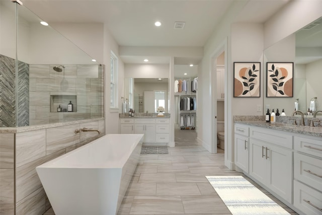 full bathroom featuring separate shower and tub, vanity, and toilet