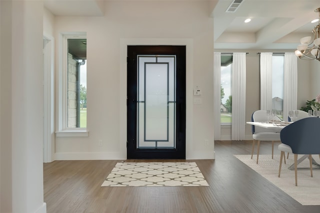 entryway featuring hardwood / wood-style flooring and a notable chandelier