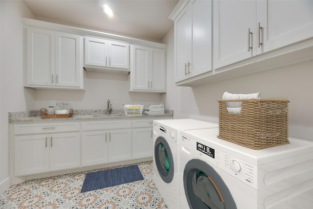 clothes washing area with cabinets, light tile patterned floors, washer and clothes dryer, and sink