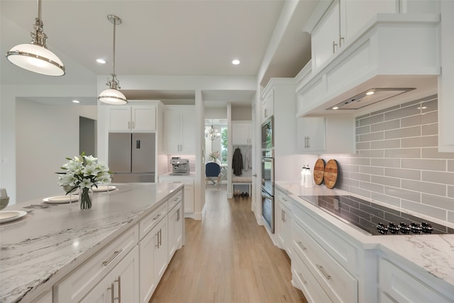 kitchen featuring white cabinets, backsplash, black electric cooktop, and stainless steel microwave