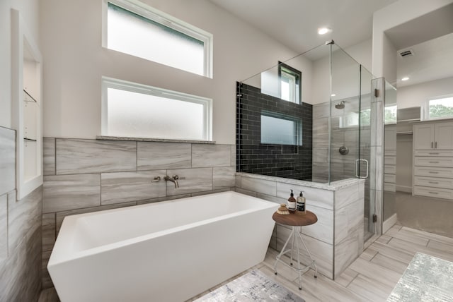 bathroom featuring separate shower and tub and plenty of natural light