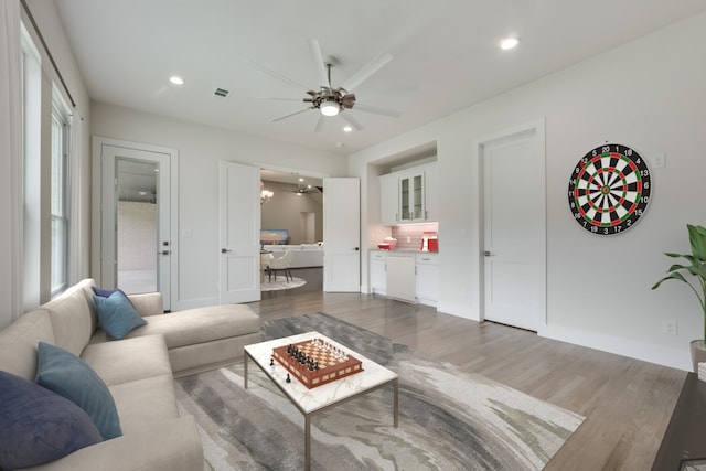 living room featuring ceiling fan and dark wood-type flooring