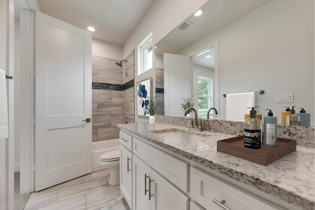 full bathroom featuring vanity, toilet, and tiled shower / bath combo