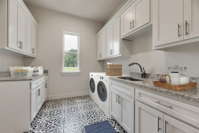 washroom with light tile patterned flooring, cabinets, sink, and washing machine and dryer