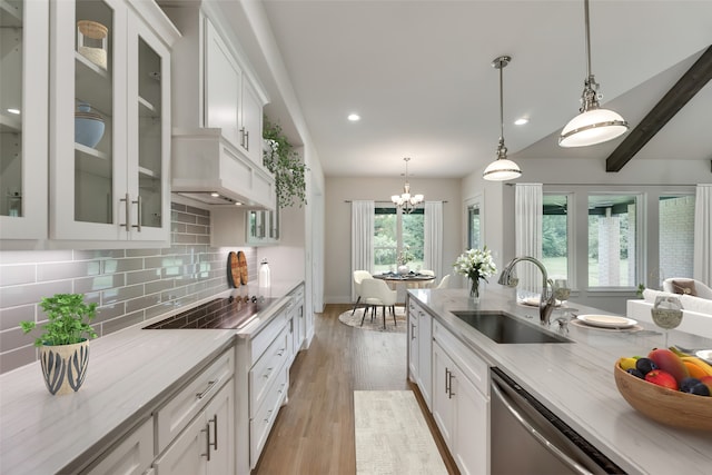 kitchen featuring black electric cooktop, sink, beamed ceiling, white cabinets, and hanging light fixtures