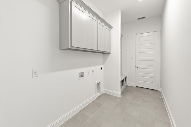 clothes washing area with hookup for a washing machine, light tile patterned flooring, hookup for an electric dryer, hookup for a gas dryer, and cabinets