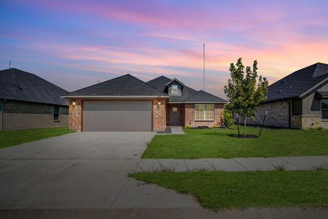 view of front of home with a garage and a yard