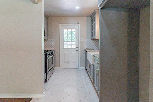 kitchen with gray cabinetry, backsplash, stainless steel appliances, and light tile patterned flooring