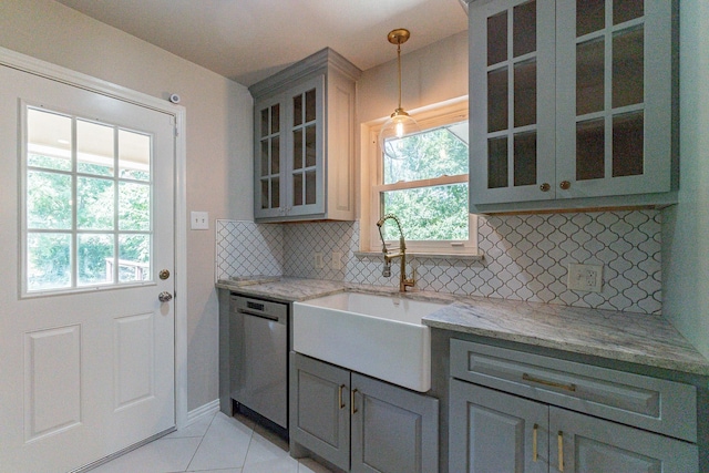 kitchen with decorative light fixtures, sink, backsplash, stainless steel dishwasher, and light stone countertops