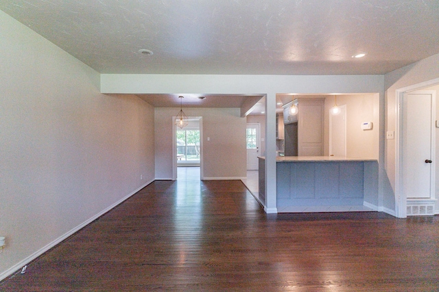 unfurnished living room with dark wood-type flooring