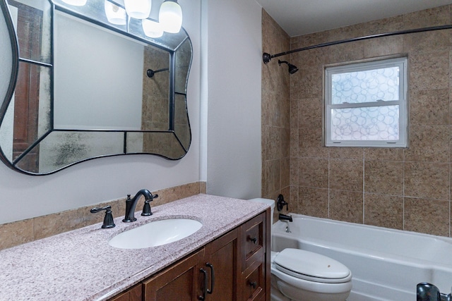 full bathroom featuring tiled shower / bath combo, vanity, and toilet