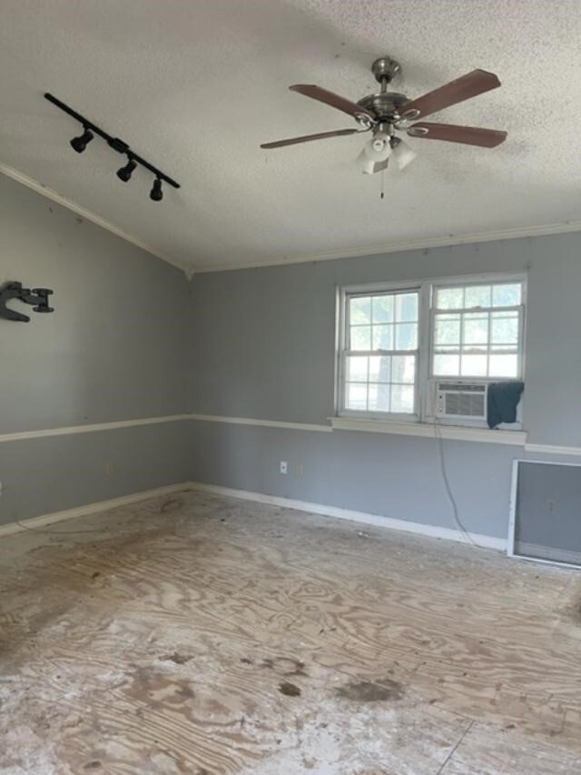 empty room with cooling unit, ceiling fan, rail lighting, and a textured ceiling