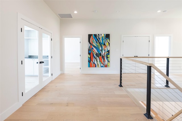 hallway featuring light hardwood / wood-style floors and french doors