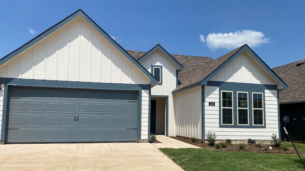 modern inspired farmhouse with a garage and a front yard