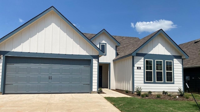 modern farmhouse style home with driveway, an attached garage, a shingled roof, and board and batten siding