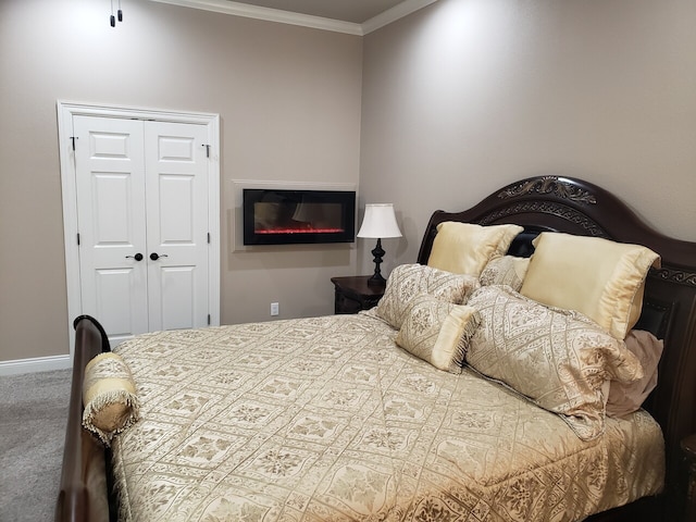 bedroom with carpet floors, crown molding, and a closet