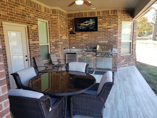 view of patio with sink, area for grilling, ceiling fan, and exterior kitchen