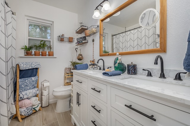 bathroom featuring double sink vanity and toilet