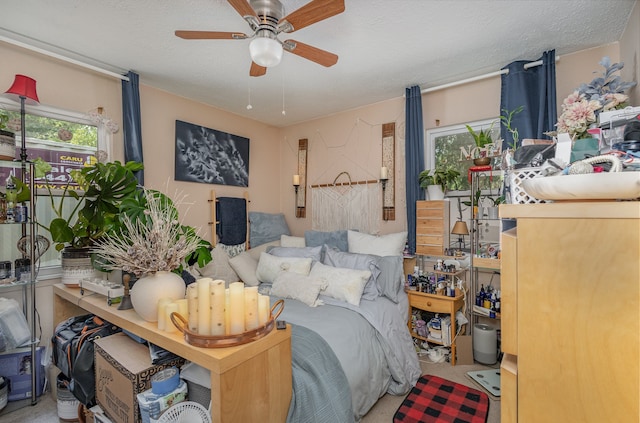 bedroom featuring multiple windows, a textured ceiling, and ceiling fan