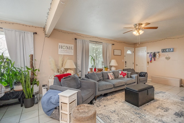 living room featuring a textured ceiling, tile patterned floors, and ceiling fan