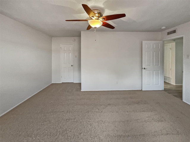 empty room with ceiling fan and dark carpet