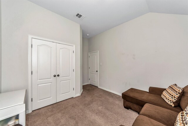 unfurnished room with lofted ceiling and light carpet