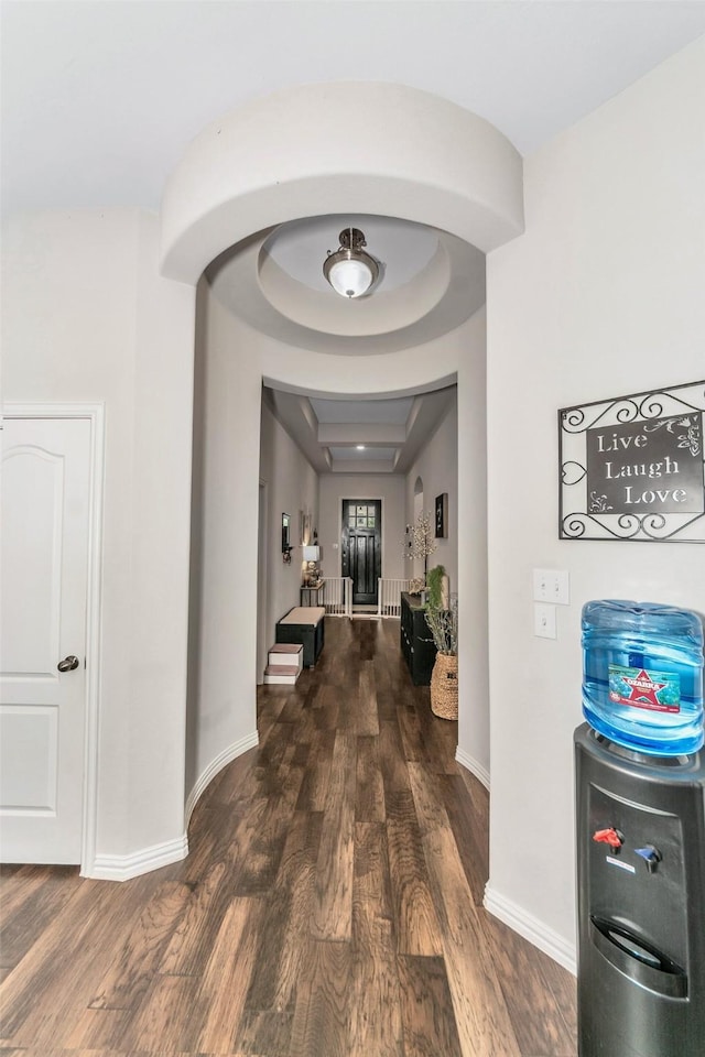 hallway featuring a raised ceiling and dark hardwood / wood-style floors