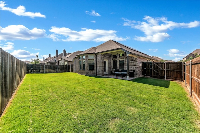 back of property with a patio area and a lawn