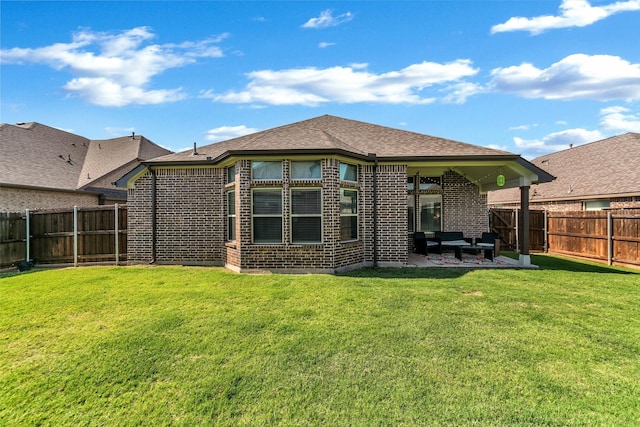 rear view of house with a lawn and a patio