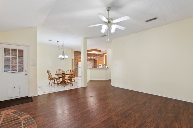 unfurnished living room with a textured ceiling, lofted ceiling, hardwood / wood-style floors, and ceiling fan with notable chandelier