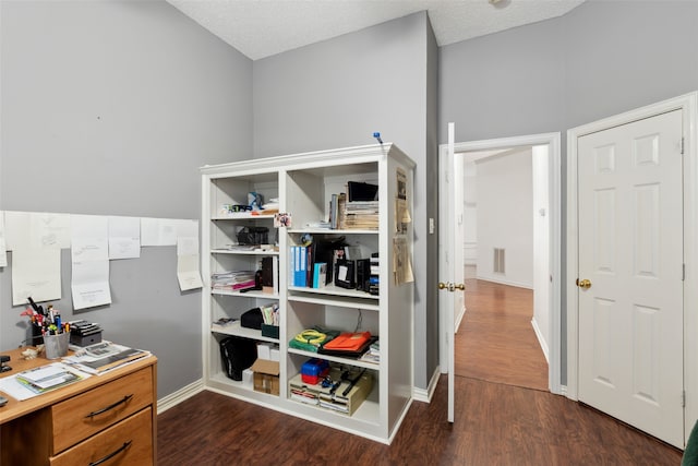 interior space featuring a textured ceiling and dark wood-type flooring