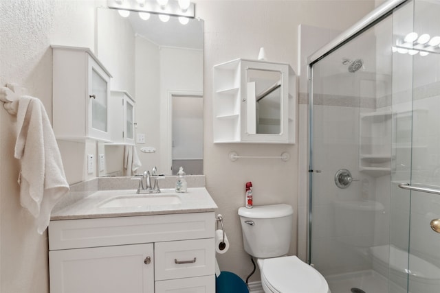 bathroom with a shower with door, vanity, and toilet