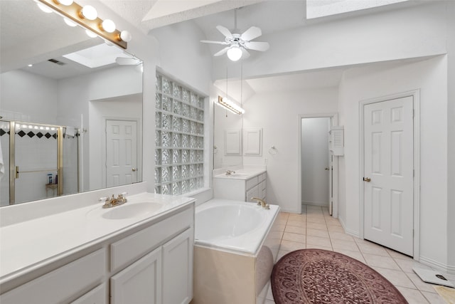 bathroom featuring tile patterned flooring, vanity, a skylight, and independent shower and bath