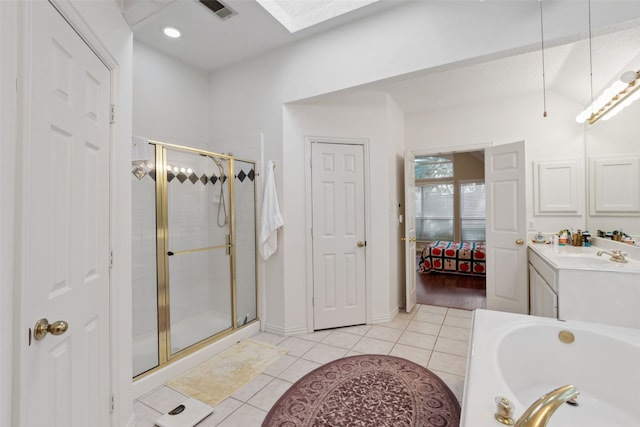 bathroom with vanity, tile patterned flooring, plus walk in shower, and a skylight