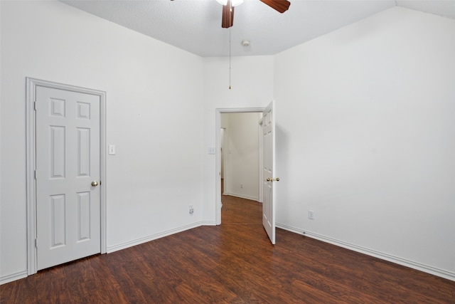 spare room with dark hardwood / wood-style floors, vaulted ceiling, and ceiling fan